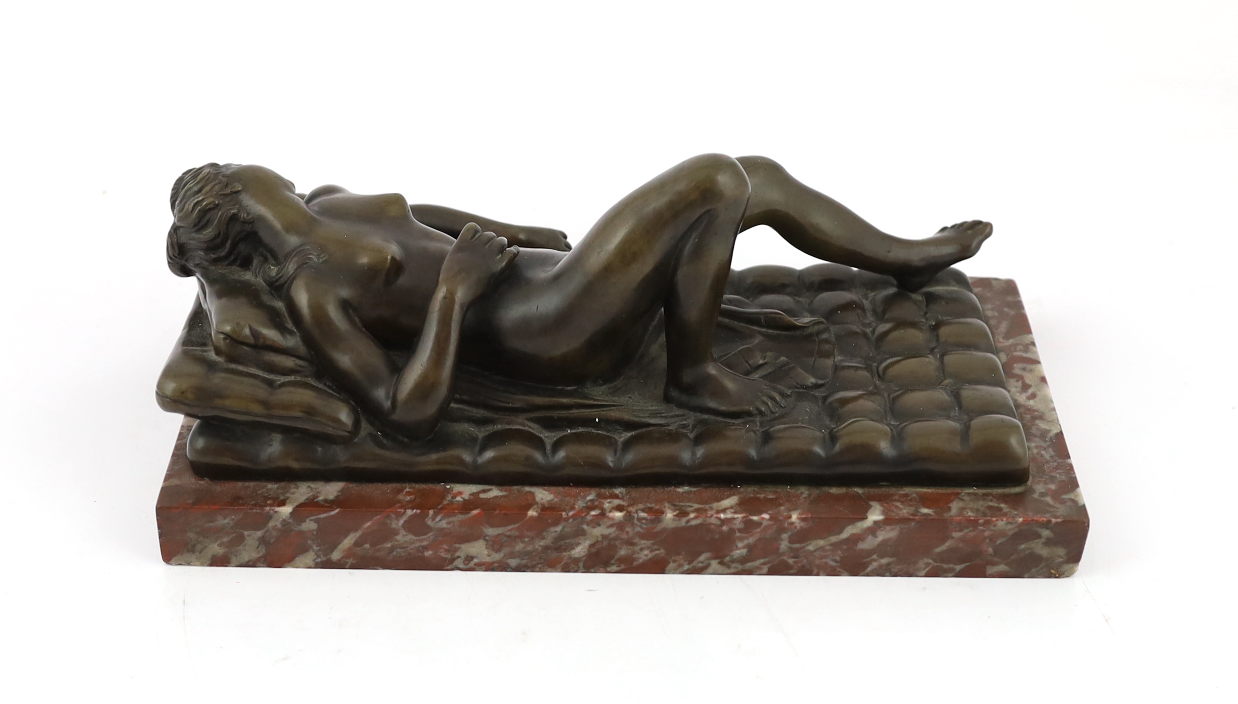 A late 19th/early 20th century bronze female nude reclining on a bed, on a red marble base, 32cm long